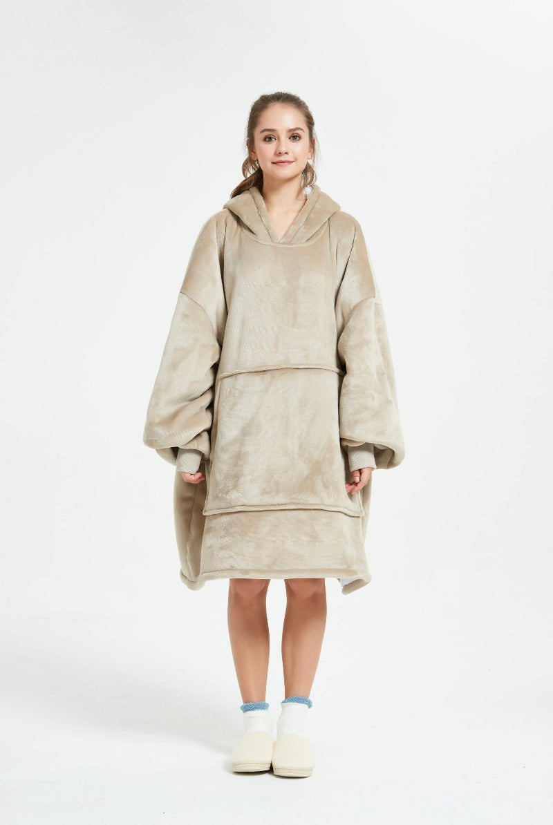 A front view of a beige Cozify plush wearable blanket hoodie, showing its large pocket, soft velvety texture, and cozy oversized design.