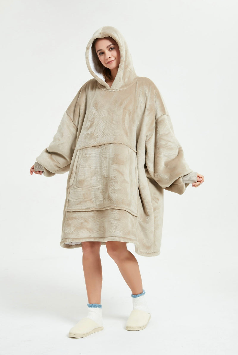 A front view of a beige Cozify plush wearable blanket hoodie, showing its large pocket, soft velvety texture, and cozy oversized design.