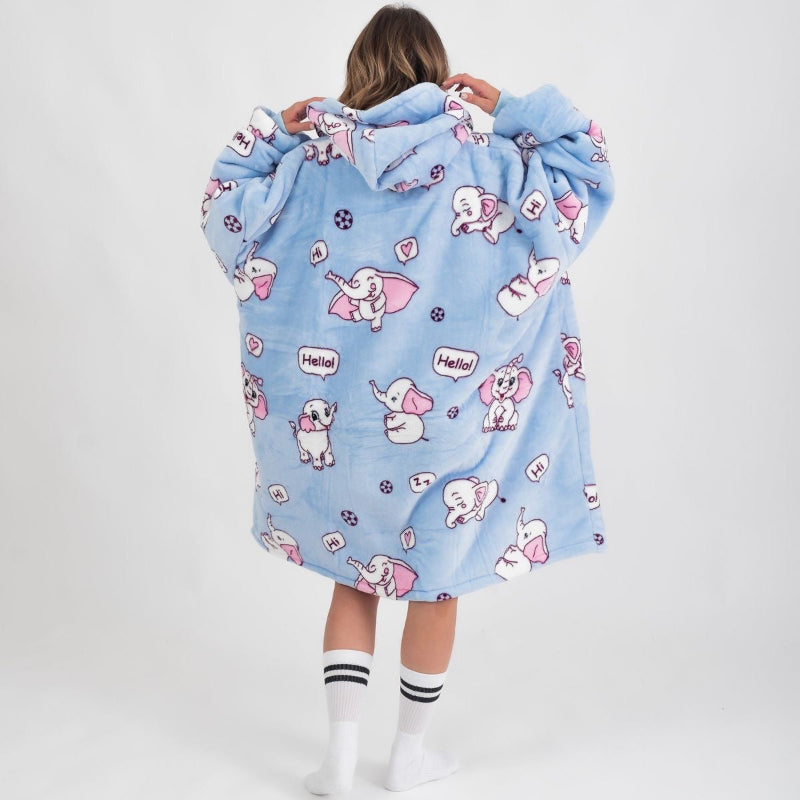 Back view of a person wearing a light blue oversized hoodie featuring a playful pink and white elephant print with speech bubbles saying "Hello" and "Hi", along with small decorative elements like hearts and balls. The hoodie has a cozy, relaxed fit with a hood and dropped shoulders.