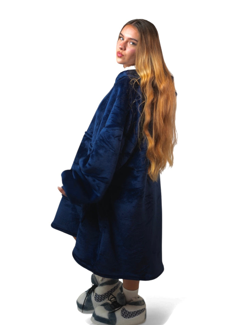 Woman posing with a turned back view in a navy blue oversized Cozify sherpa-lined hoodie blanket, showing off the relaxed fit and plush texture.