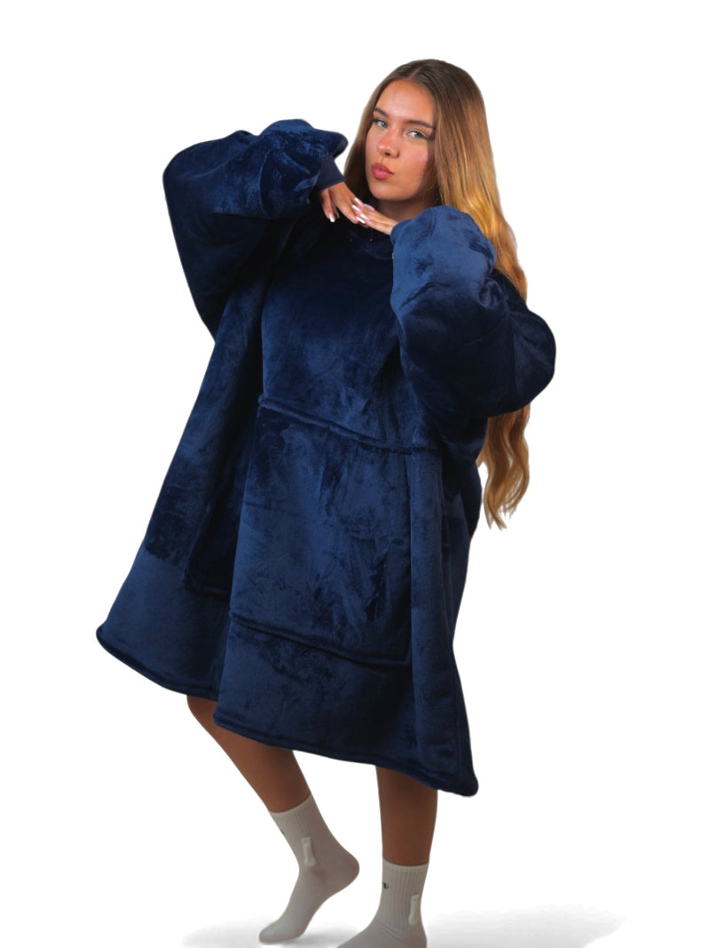 Woman posing in a navy blue oversized Cozify sherpa-lined hoodie blanket with a large front pocket.