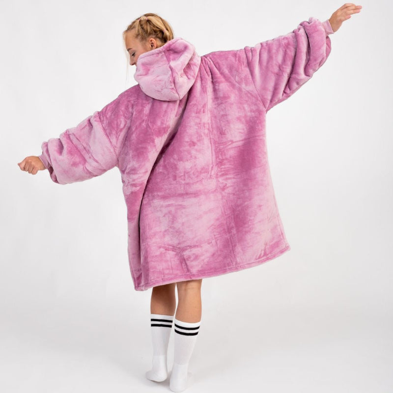 Back view of a person wearing a plush, oversized hoodie in solid pink. The hoodie has a soft, velvety texture, with a hood and extra-roomy sleeves. The person has their arms outstretched, showcasing the cozy and relaxed fit of the garment.