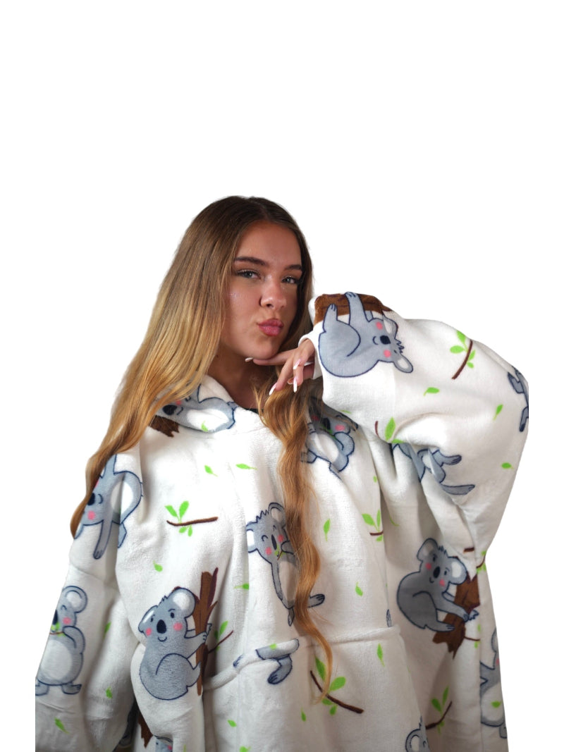 Woman posing in an off-white oversized wearable blanket hoodie with a cute koala bear print, shown close-up against a white background.